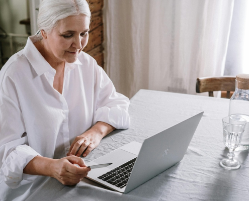 Elderly lady checking her Drop Shipping website profits on laptop