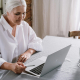 Elderly lady checking her Drop Shipping website profits on laptop