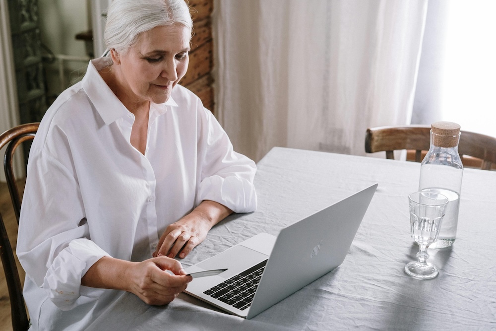 Elderly lady checking her Drop Shipping website profits on laptop